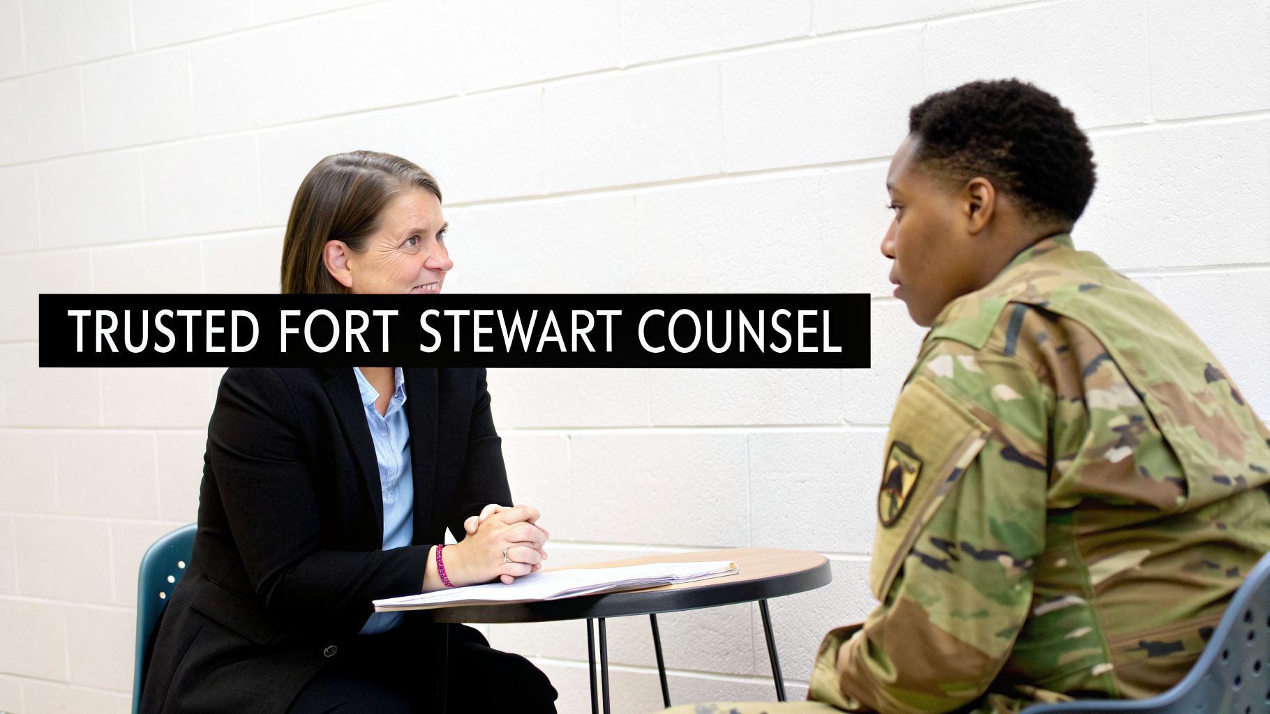 A legal professional in a suit consults with a soldier in camouflage at a table.